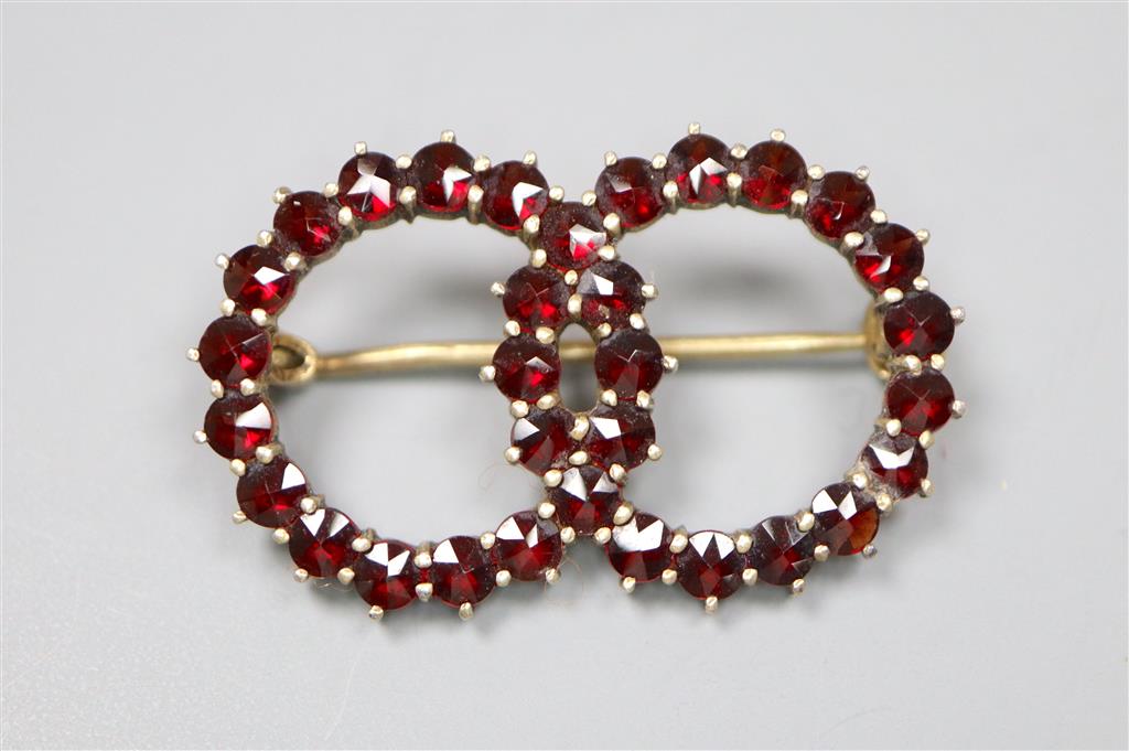 A late Victorian gilt white metal and facet cut garnet set twin sphere brooch, 30mm, gross 3.5 grams.